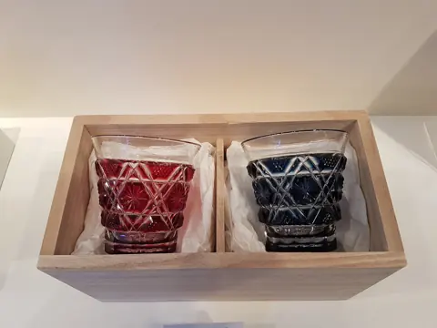 A pair of red and blue Japanese cut-glass tumblers in a wooden box