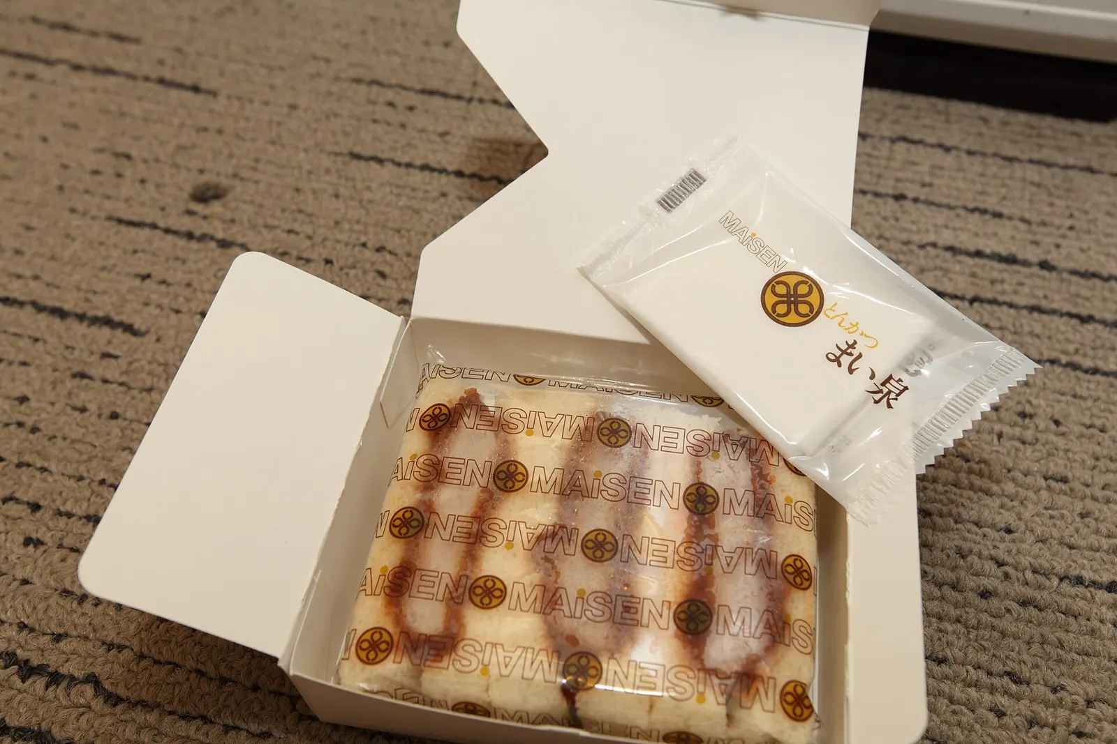 打开的日本纸盒，里面有一颗包好的糖果