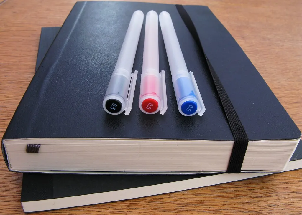 Schwarze Notizbücher und Stifte auf einem Schreibtisch, bereit für ein neues Jahr